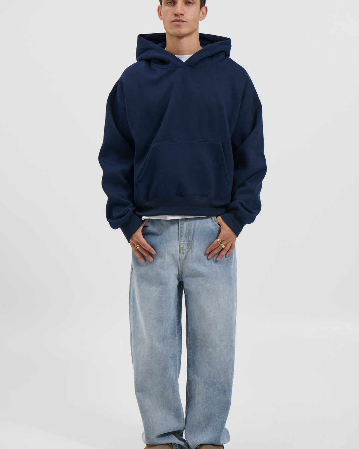 Ragazzo con felpa blu e jeans chiari: lo stesso outfit indossato