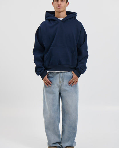 Ragazzo con felpa blu e jeans chiari: lo stesso outfit indossato