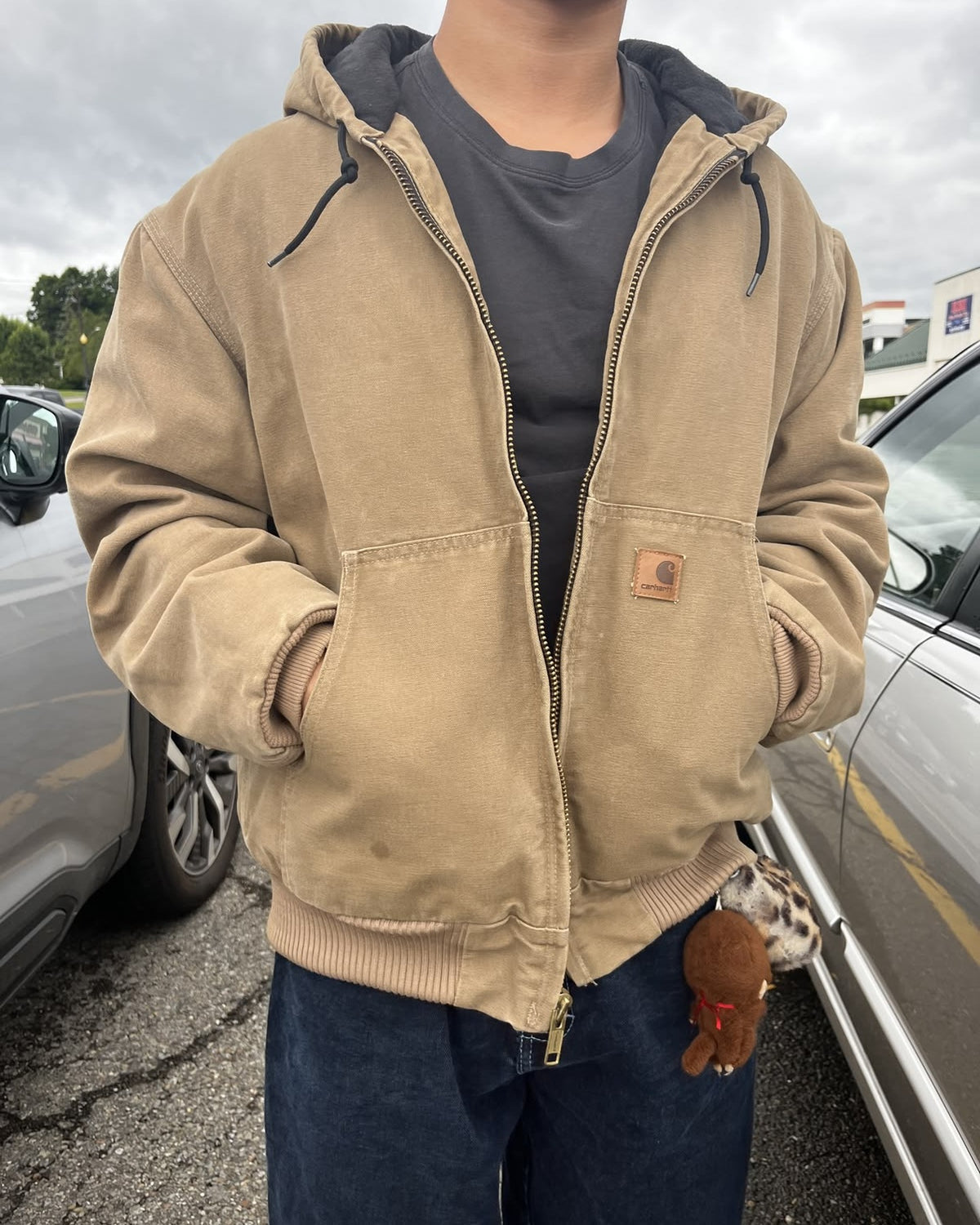 Ragazzo con giacca color tabacco e jeans scuri: lo stesso outfit indossato