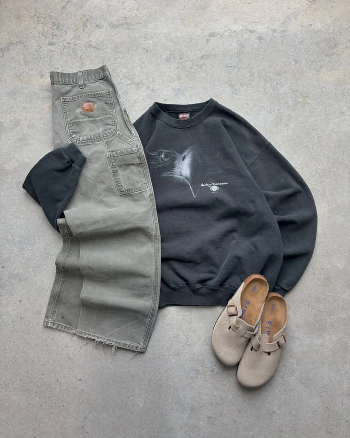 Outfit vintage steso a terra: felpa blu e pantalone verde oliva